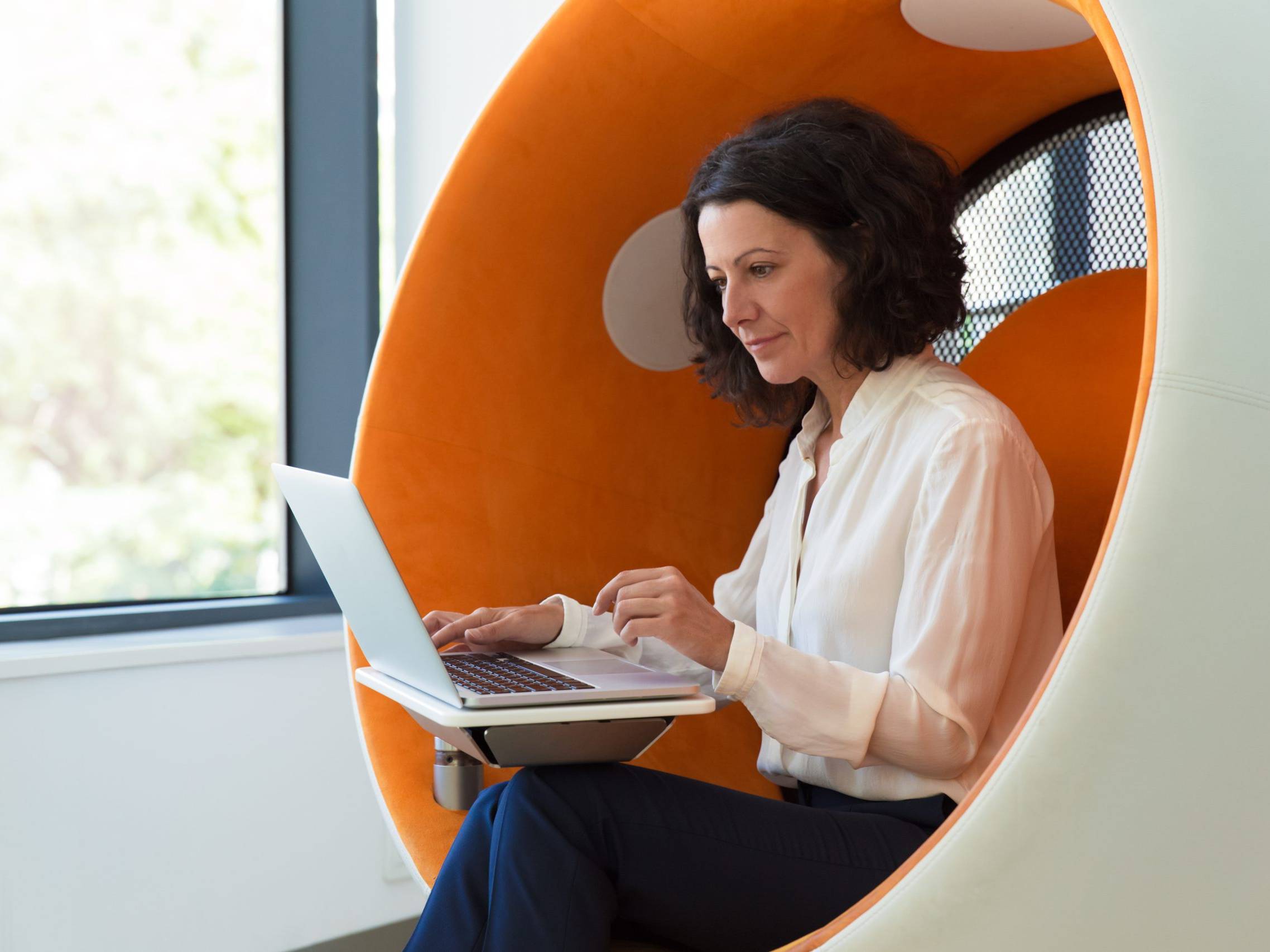 Femme d&rsquo;affaires concentr&eacute;e travaillant sur un ordinateur portable dans un espace de bureau.